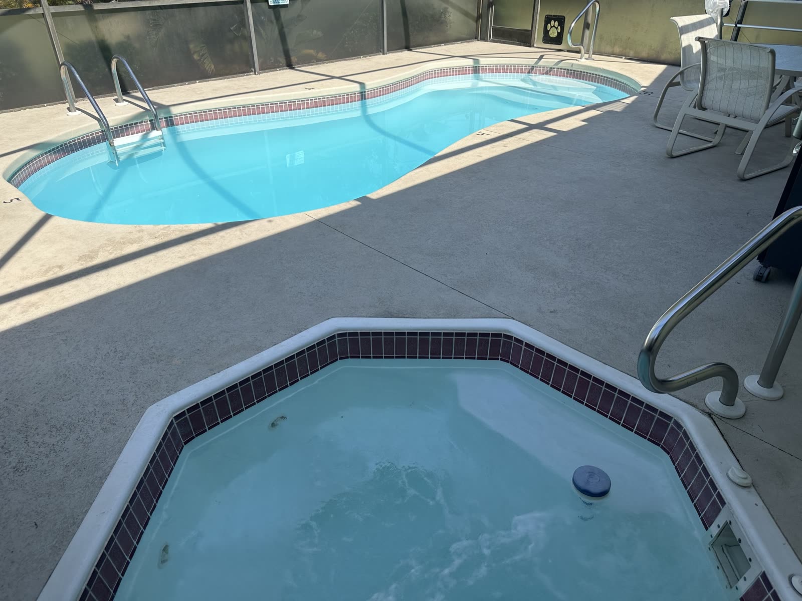 Sunshine Villa hot tub and pool on the screened lanai in daylight